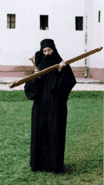 Knocking with a hammer on a wooden semantron - a traditional Orthodox device for announcing the time of prayer, Visoki Decani Monaster