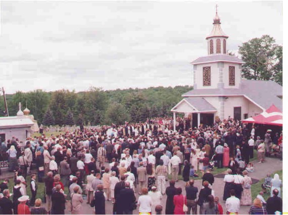 7. Vigil - This arial shot of the Vigil is taken during the Vespers portion of the service; the priests and bishops did not get fully vested until Orthros began. The large blue and white church served as the altar for this outdoor service. The red and white tent housed the clergy choir that led the singing. The small grey-stone building on the left end of the picture is the original tomb of St. Alexis Toth; on the other side of it (not visible) is the grave of Metropolitan Leonty, who led the formation of the OCA. The shot is taken from the monastery belltower