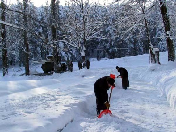 Cleaning snow - Italian guards in the background, Visoki Decani Monastery monks, Serbia