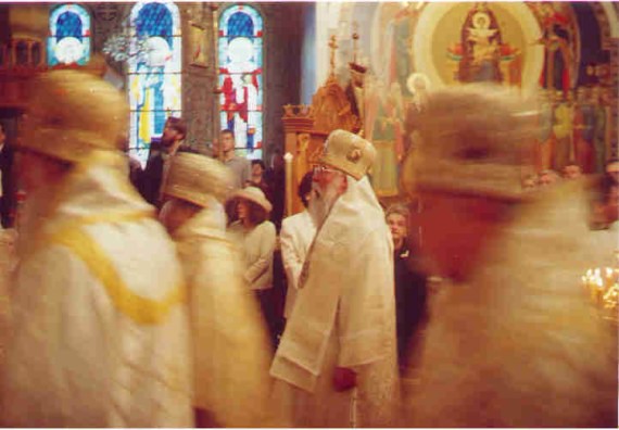 1. Before the Vigil - As the hierarchs enter, OCA Bishop Tikhon of San Francisco pauses long enough to be captured on film in the main monastery chapel. Above, stained glass windows and icons filled the walls of the chapel. One could easily spend an entire service just staring at the saints