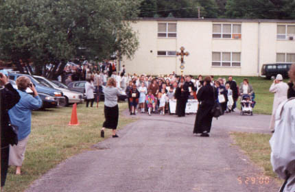 20. Procession and Divine Liturgy - A monk of St. Tikhon of Zadonsk monastery carries a cross in the procession just before the glorification Liturgy. He is followed by children carrying icons, who are followed by the relics and the hierarchs[not seen in this picture]